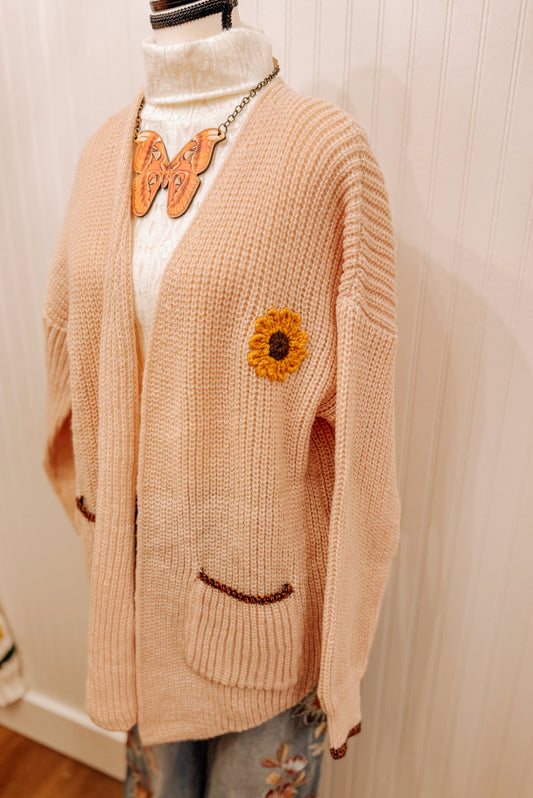 Peach knit sunflower cardigan.